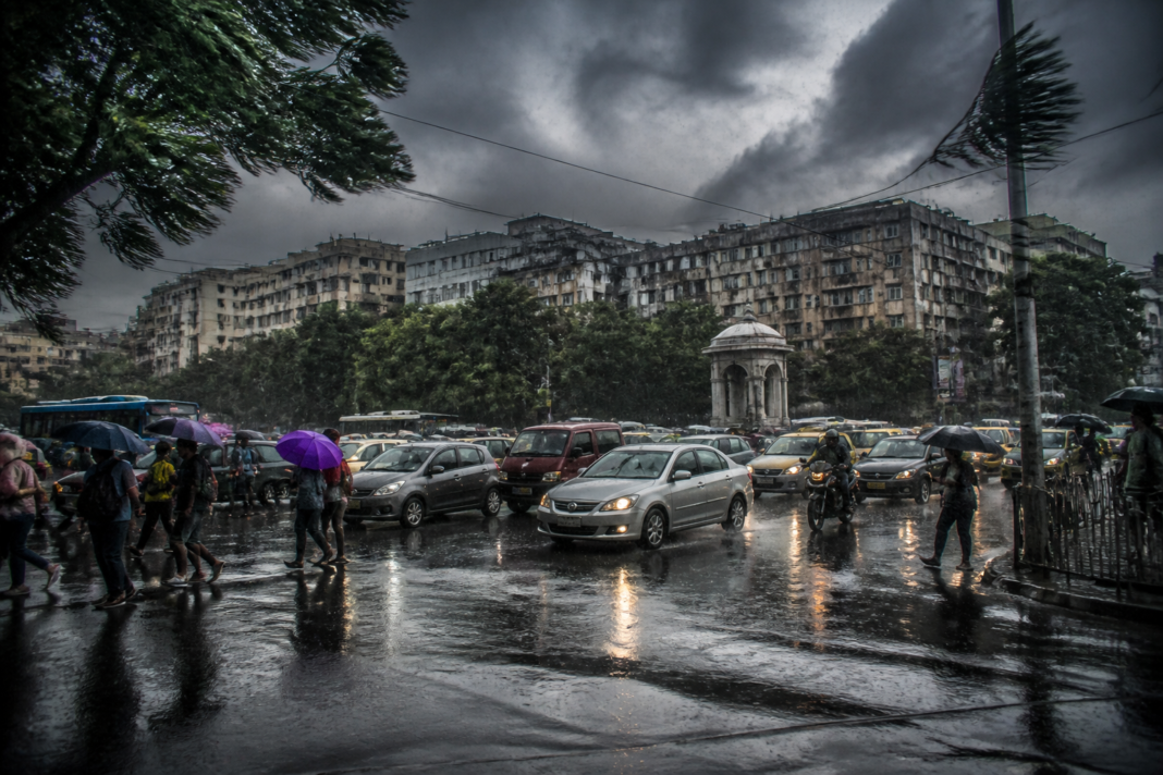 Kolkata rain forecast showing dark monsoon clouds over a rain-wet Kolkata street