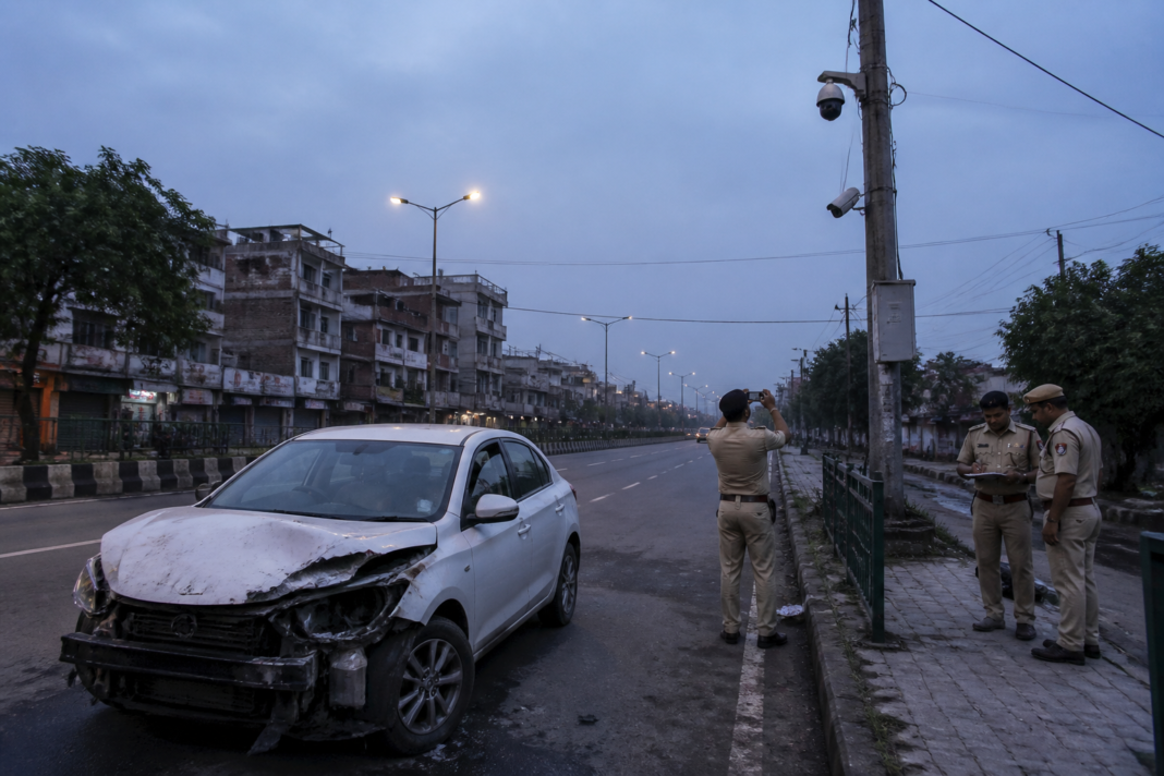 Nangloi hit-and-run site on a Delhi road before dawn with police vehicles and damaged car