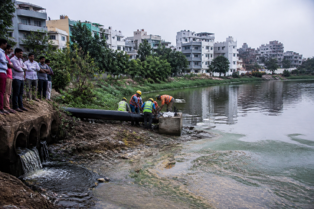 Bengaluru lakes project pipeline near a polluted urban lake and surrounding homes