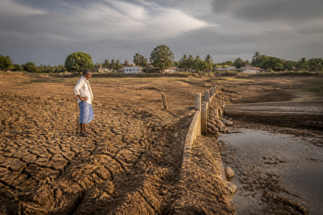 Karnataka drought affecting a dry agricultural landscape with a depleted irrigation tank