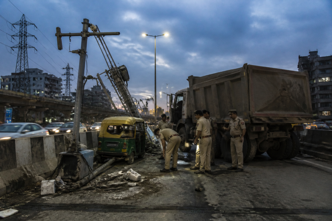 Delhi dumper accident site near Sarita Vihar with a stationary crane and damaged auto-rickshaw