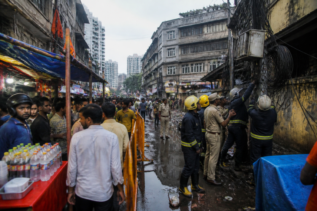 Parel electrocution site near a crowded Mumbai festival stall with barricades and emergency responders