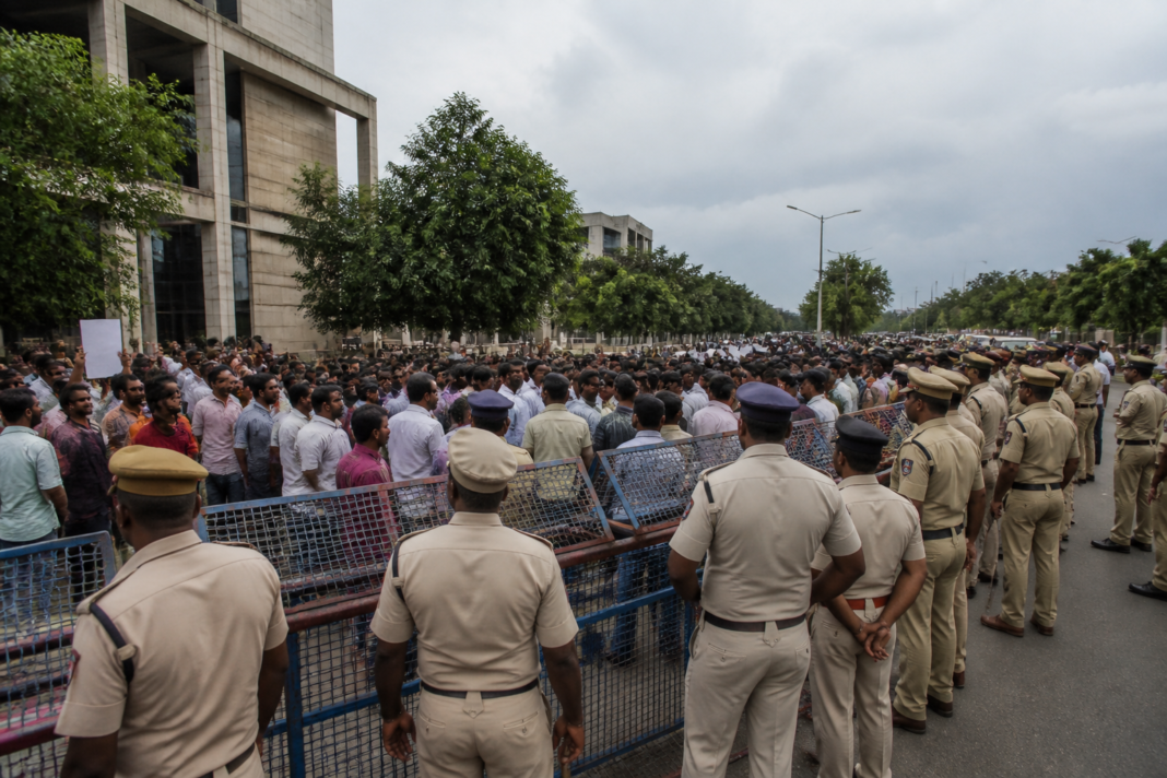 Mega DSC-2025 protest near the SAAP office in Vijayawada with police barricades and demonstrators.