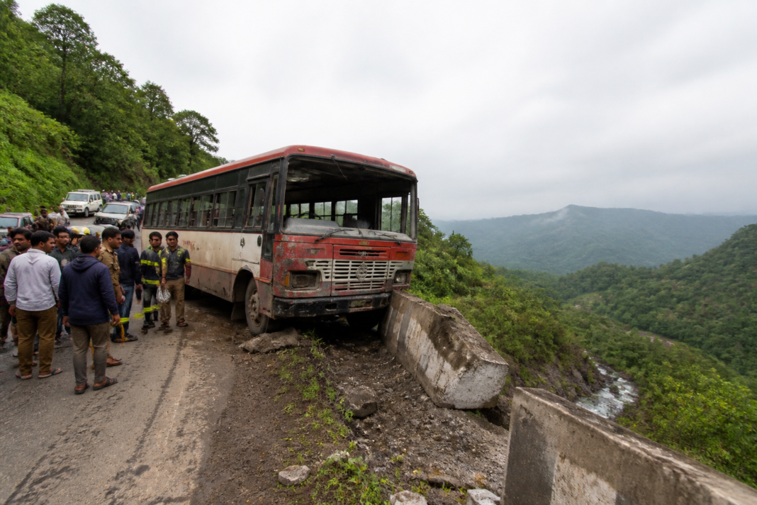 Shahapur ST bus accident scene near a roadside protective wall on a steep road