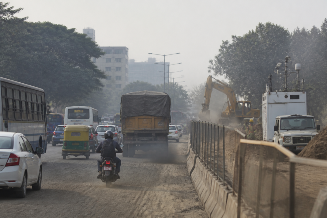 Bengaluru air quality monitoring near a busy road with construction dust and traffic