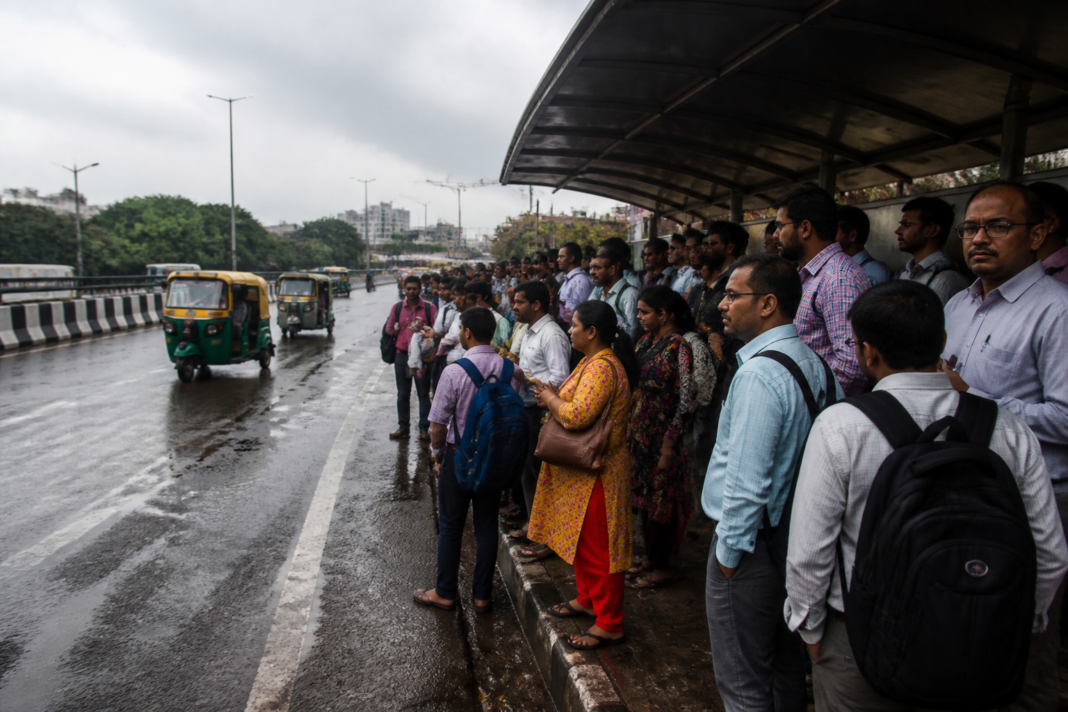 Delhi bus strike leaves commuters waiting at a crowded bus stop