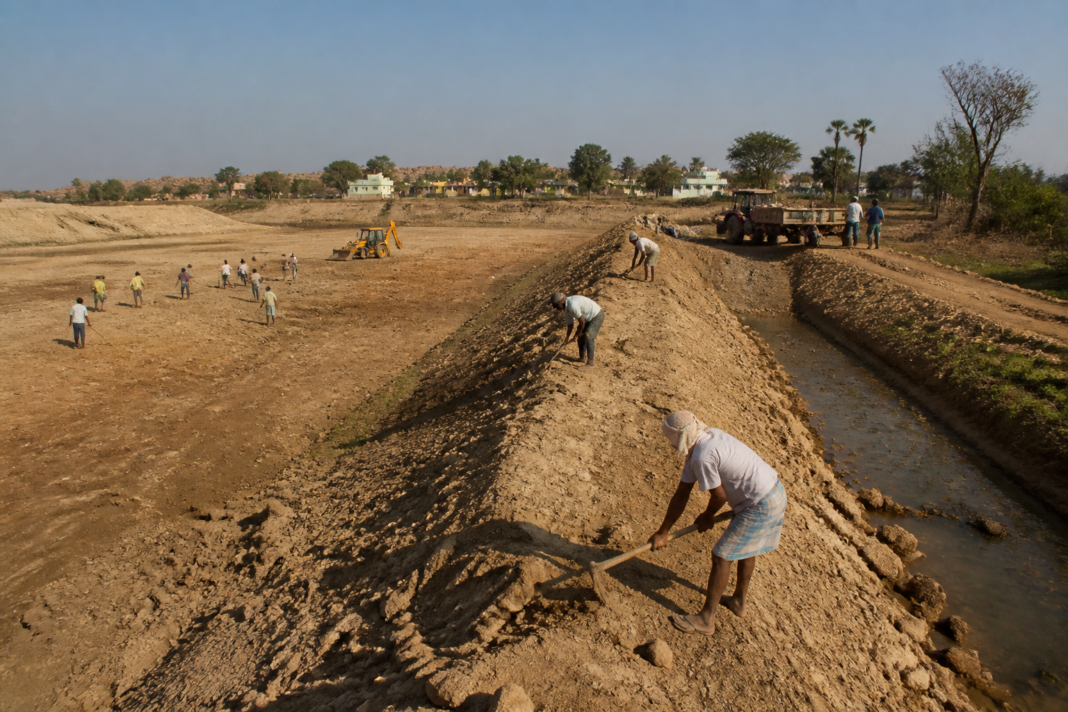 Karnataka lake rejuvenation work at a dry lake with restored bunds and rural workers