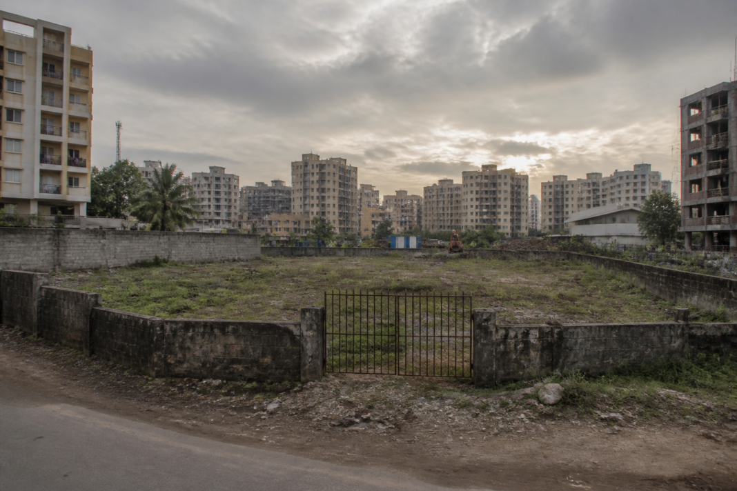 Bhayandar land dispute site with urban buildings and boundary fencing in Mira-Bhayandar