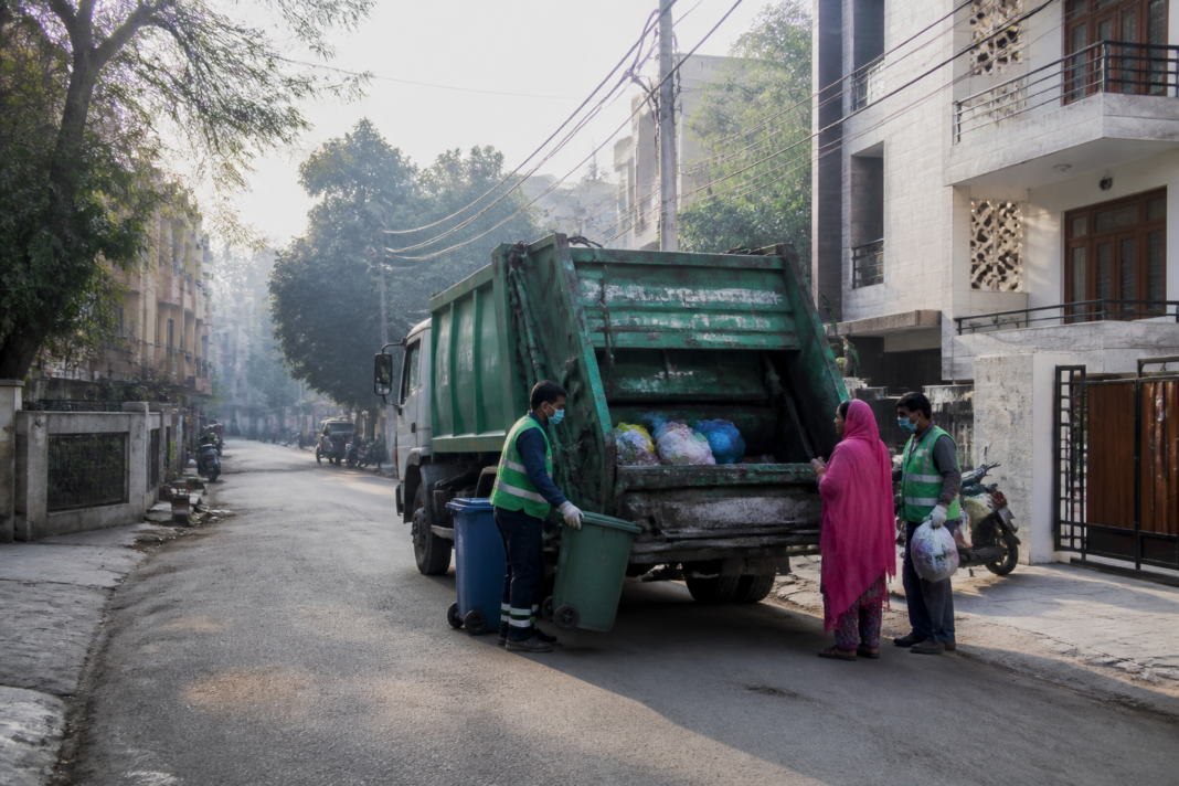 MCD waste charges proposal shown through a Delhi municipal waste collection vehicle on a residential street