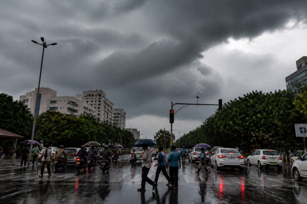 Telangana rain alert showing storm clouds and rain over an urban road in Hyderabad