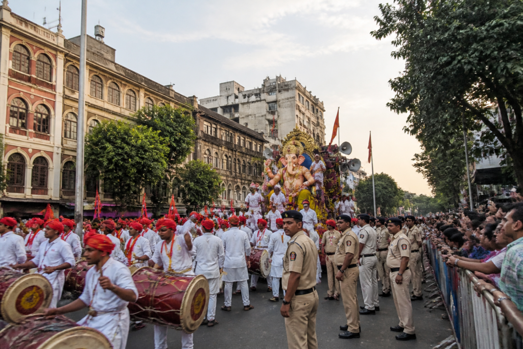 Pune Ganesh visarjan procession with dhol-tasha performers on a city road