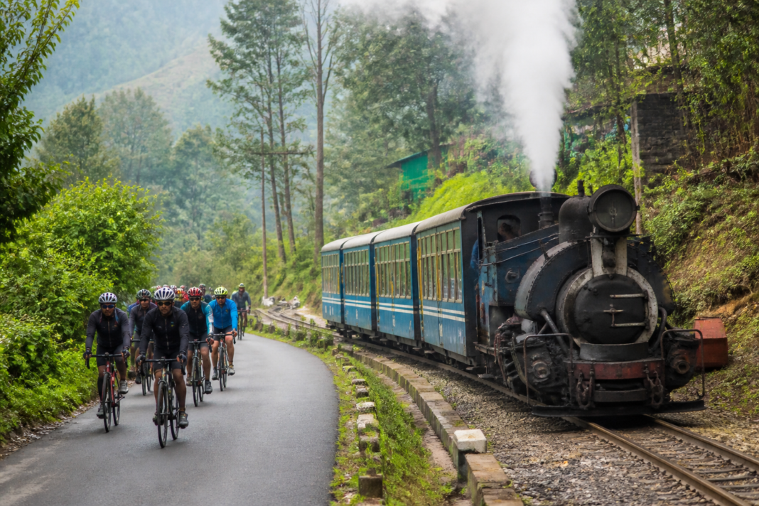 Kanchenjunga Tourism Festival cyclists riding beside the Darjeeling Himalayan Railway toy train