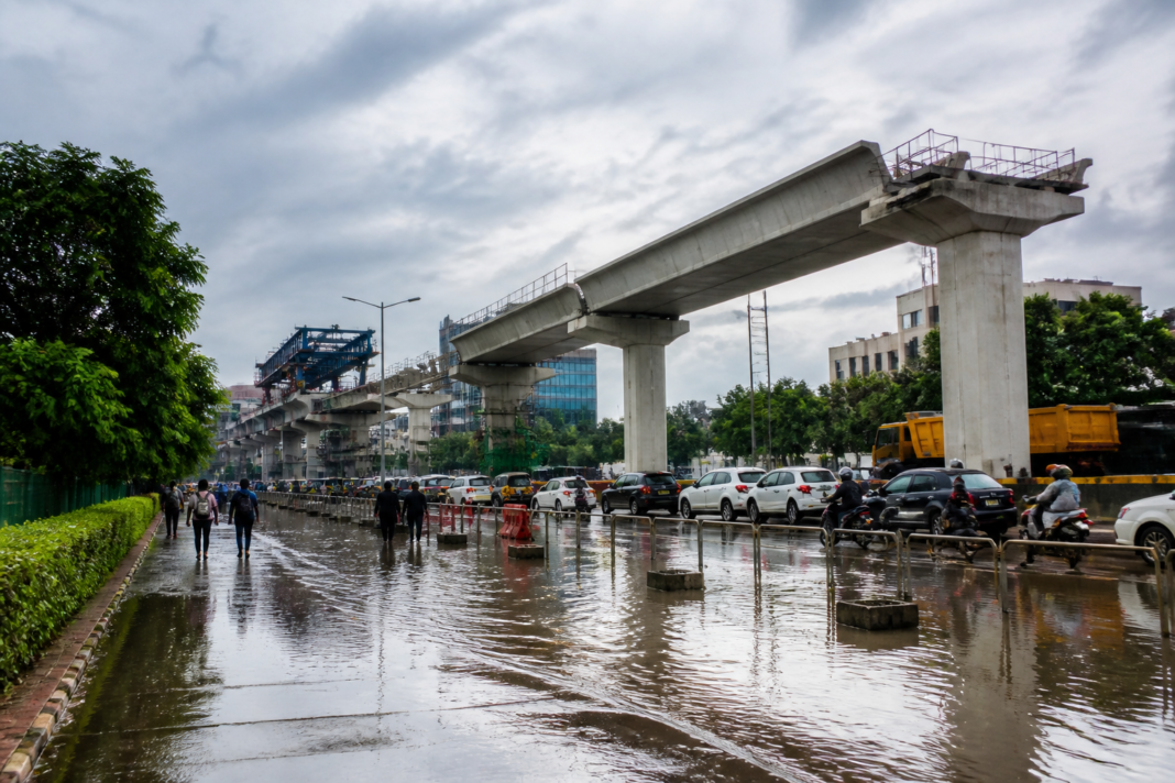 Subhash Chowk Metro Station access area near a waterlogged Gurugram road