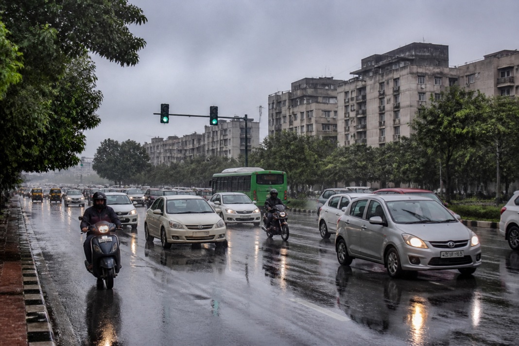 Delhi weather brings rain over roads and buildings under cloudy skies