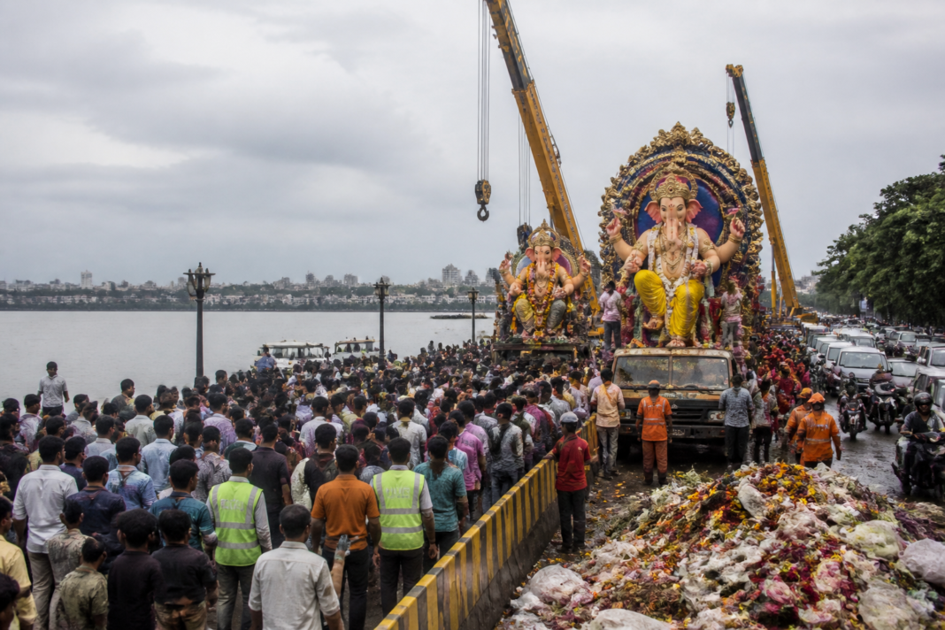 Ganesh immersions Hyderabad crowds and cranes along Hussain Sagar during a busy procession.