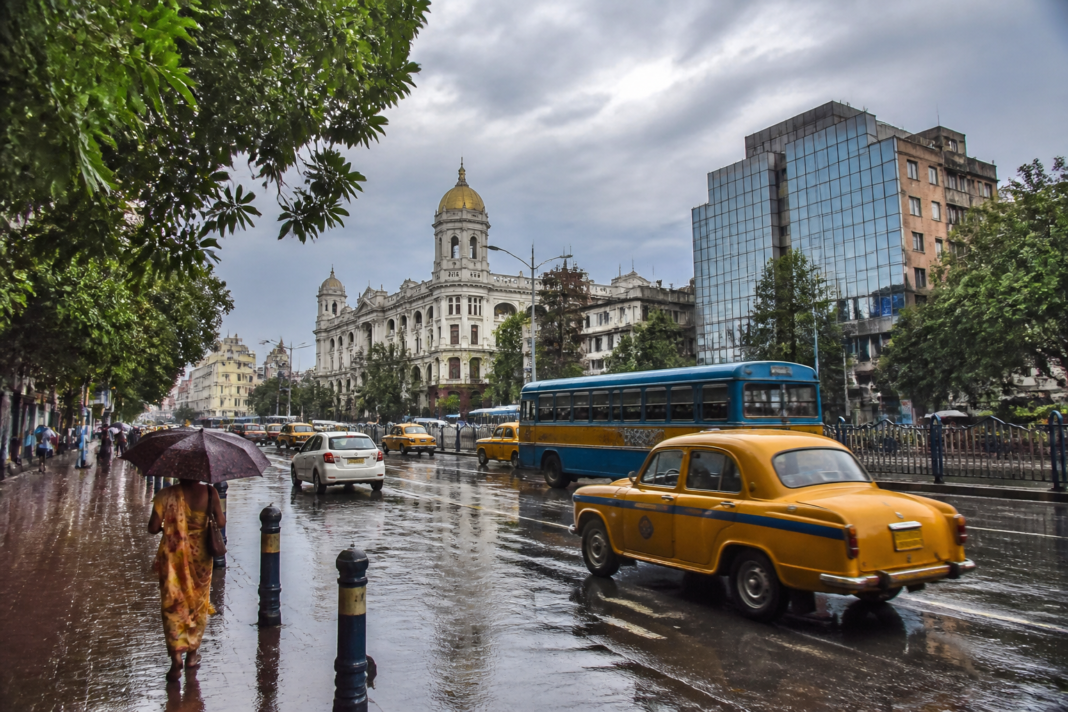 Kolkata rain forecast showing heavy monsoon showers over a city street