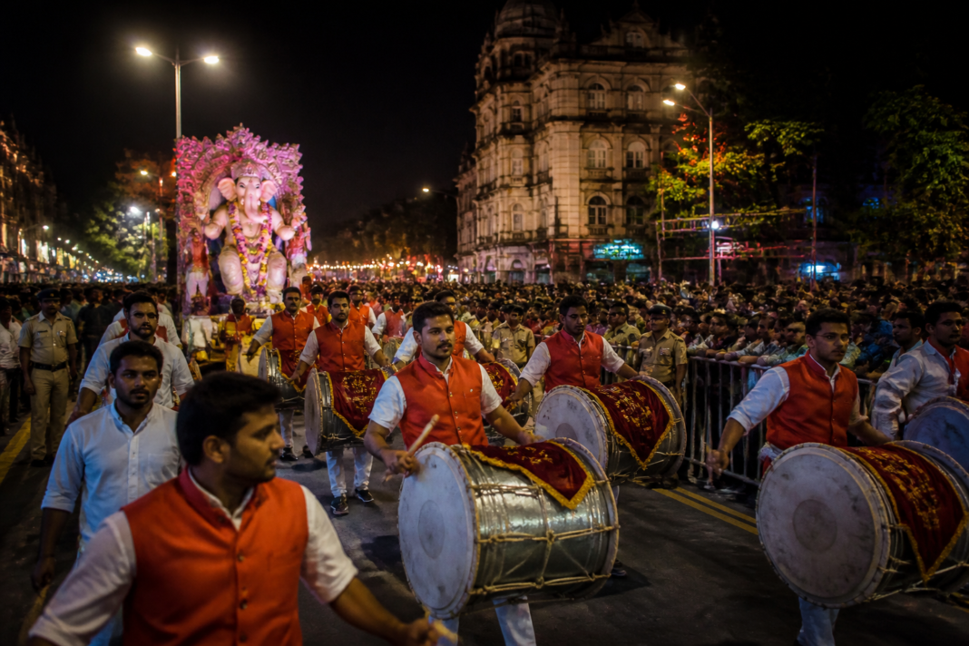 Pune Ganpati visarjan procession moving through a crowded central city road at night
