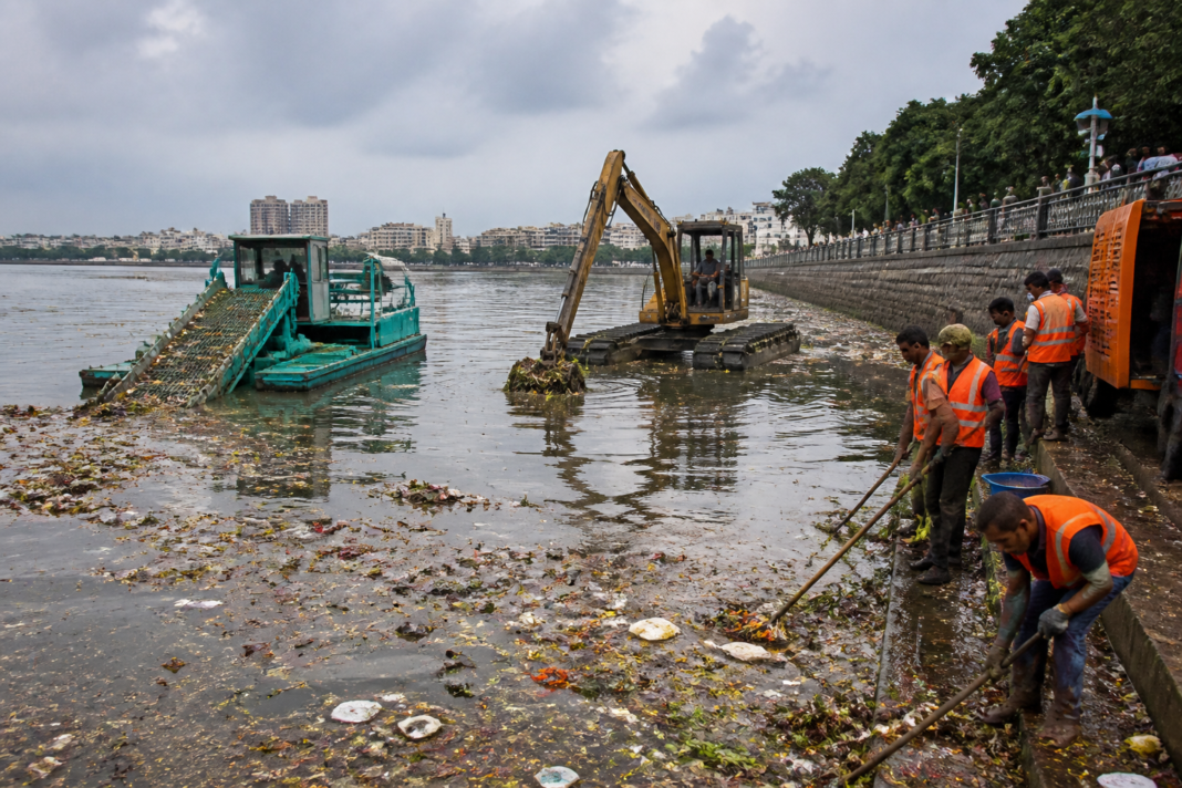 Hyderabad Ganesh immersion cleanup at Hussain Sagar with floating waste collectors on the lake