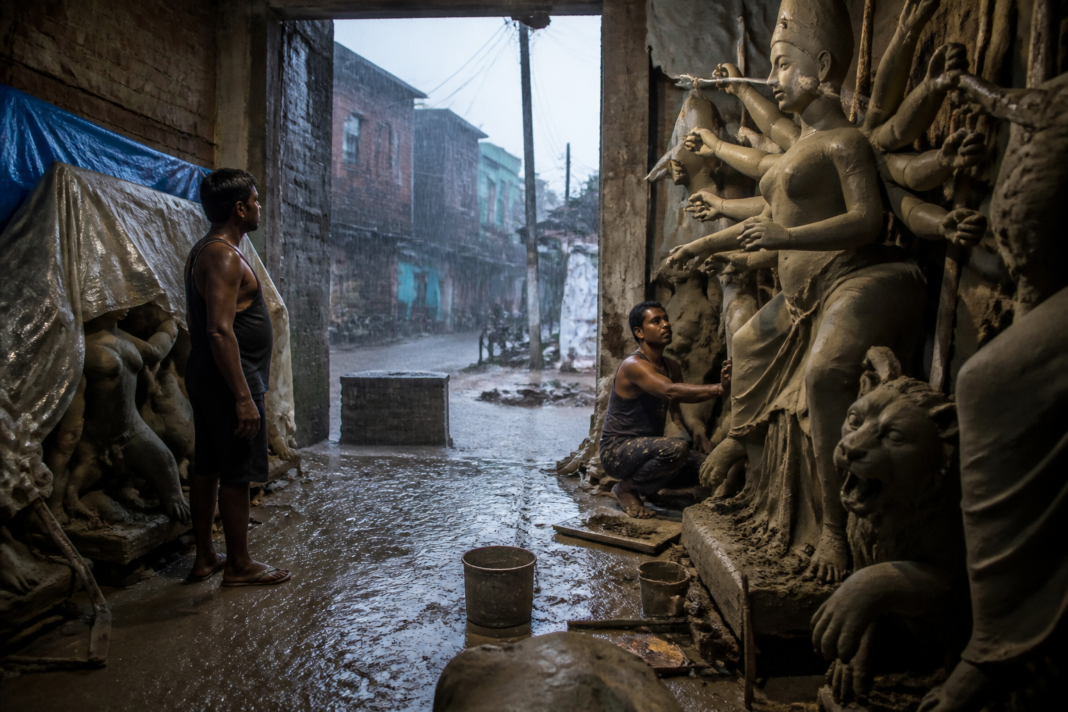 Dhanbad Durga idol makers working on clay idols during persistent rain