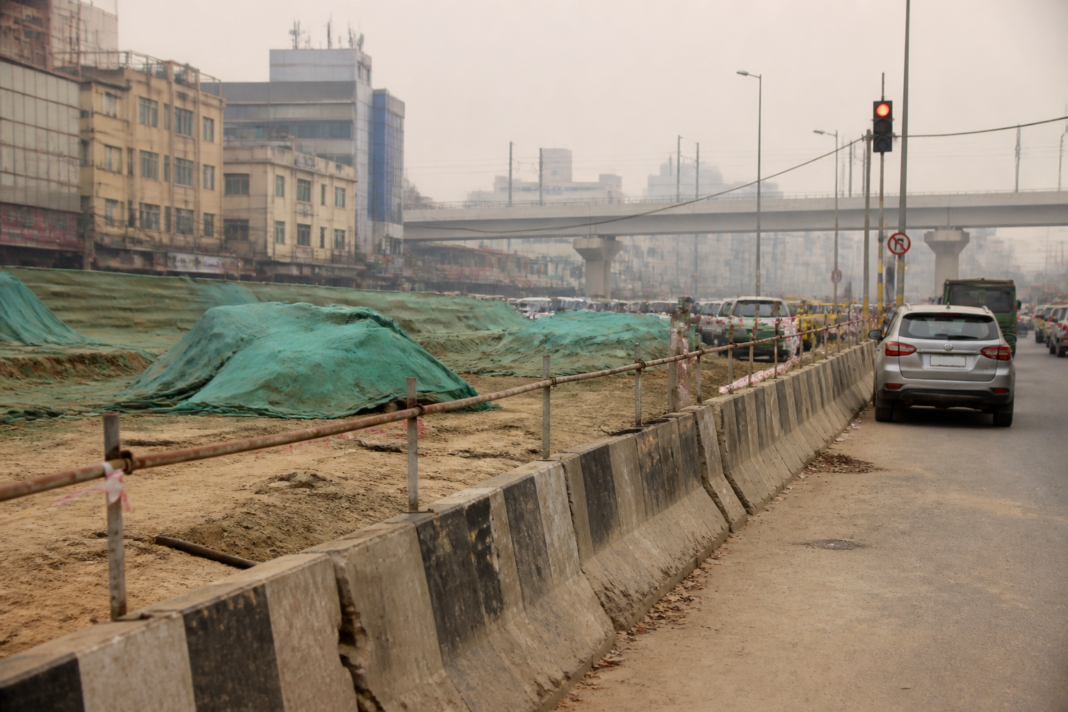 Delhi winter pollution rules shown through a dusty construction site and traffic on a city road