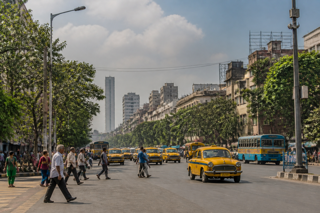 Kolkata monsoon withdrawal reflected in a dry, sunlit city street under humid late-season skies