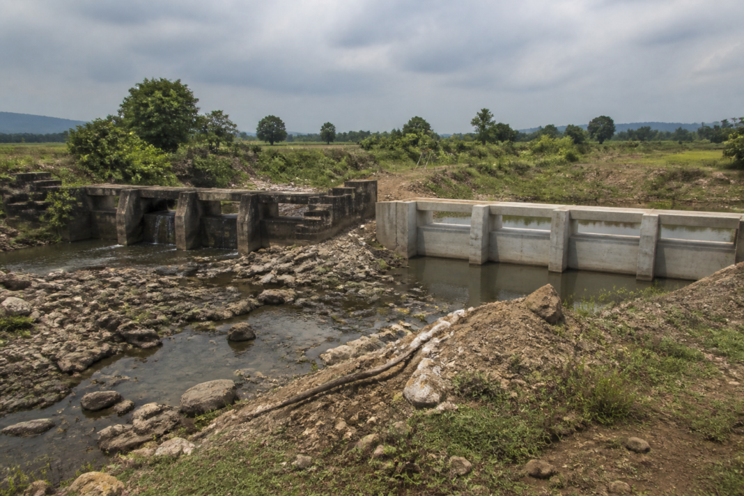 Odisha water projects check dam beside an older structure in a rural irrigation landscape