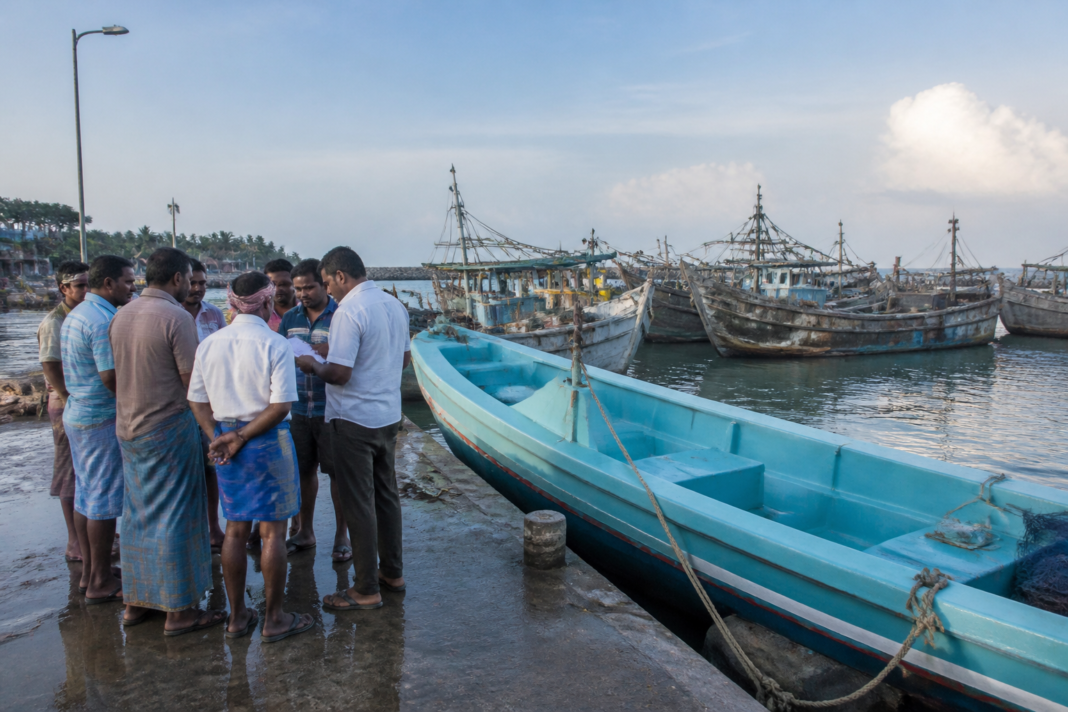 Rameswaram fishermen and fibre fishing boats at a Tamil Nadu coastal port