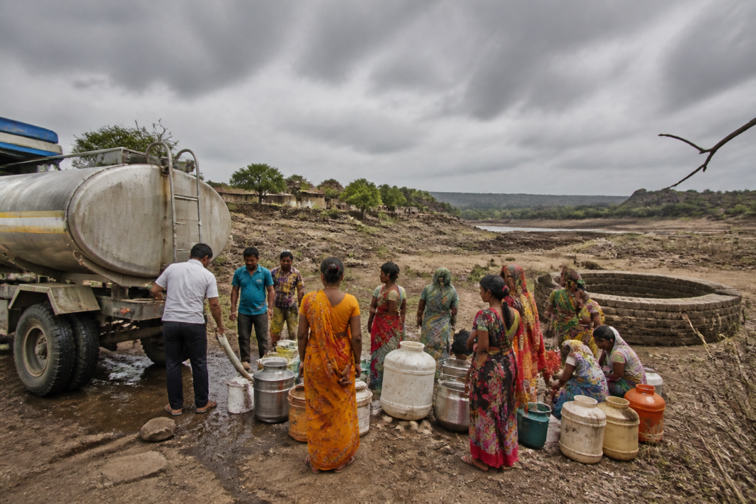Marathwada drought scene with a water tanker supplying villagers in a dry Maharashtra settlement