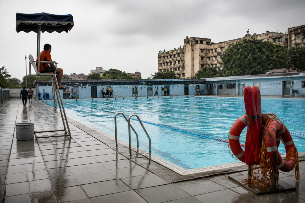 Vapi swimming pool viewed from the poolside, highlighting a municipal sports facility and safety equipment.