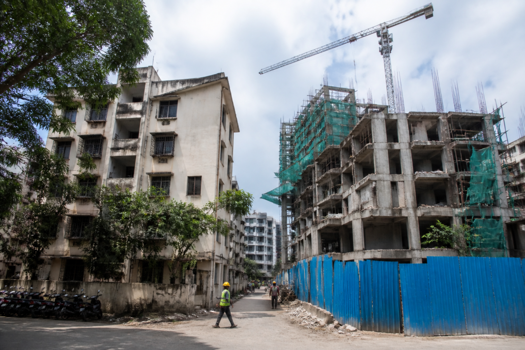 Maharashtra housing society redevelopment site with an ageing residential building and construction activity