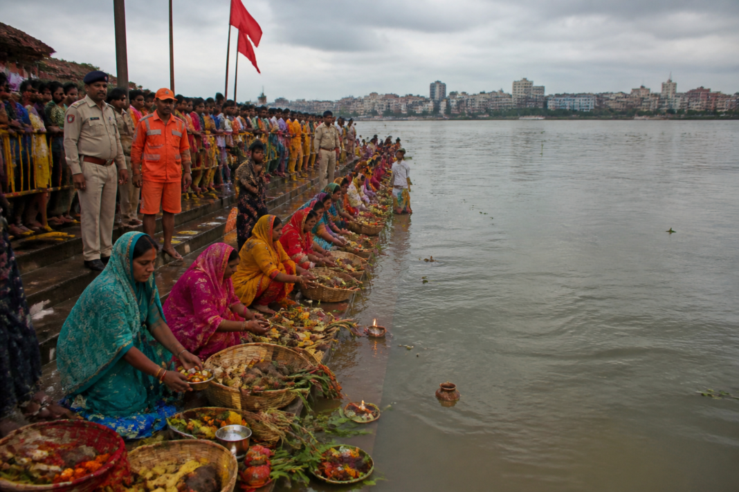 Women observing the Jitiya festival at Patna’s Ganga ghats amid safety barricades