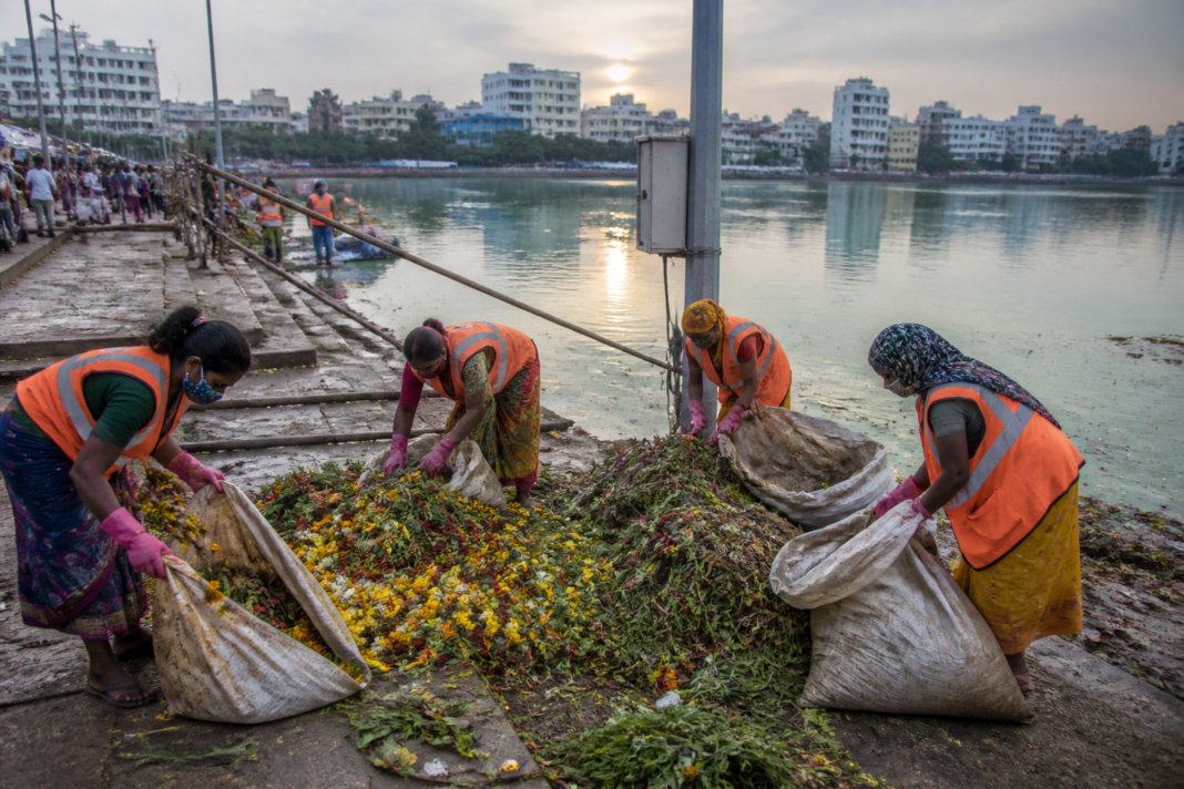 Sanitation workers collecting flower waste after Ganesh immersion in Hyderabad