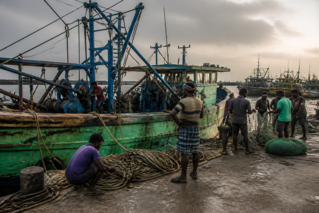 Kasimedu fishermen beside fishing trawlers at Chennai harbour