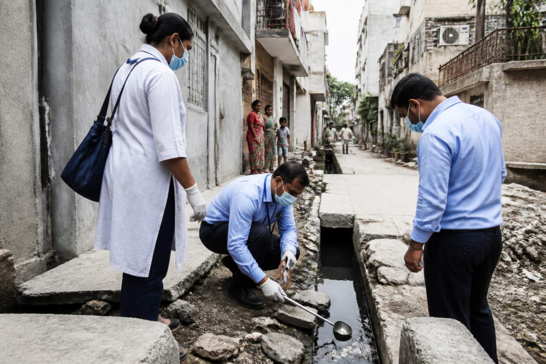 Delhi dengue cases and municipal mosquito-control workers inspecting a residential area