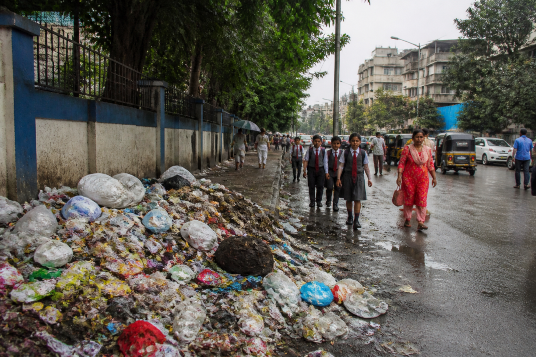 Mumbai garbage crisis with waste piled beside an urban road near a municipal area