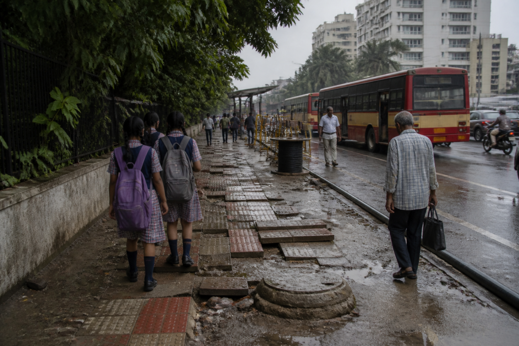 Damaged ECR footpath near a Tiruvanmiyur bus stop forcing pedestrians towards traffic