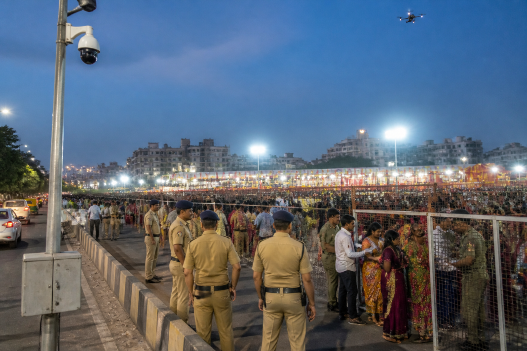 Ahmedabad Navratri security personnel monitoring a crowded garba venue with surveillance cameras