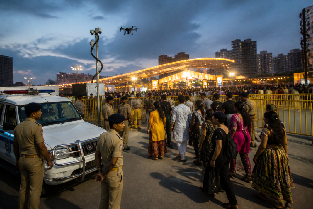 Ahmedabad Navratri security personnel monitoring a crowded garba venue with cameras and patrol vehicles.
