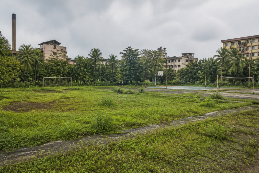 Overgrown FACT sports grounds in Kalamassery, including a neglected playing field and sports facilities.