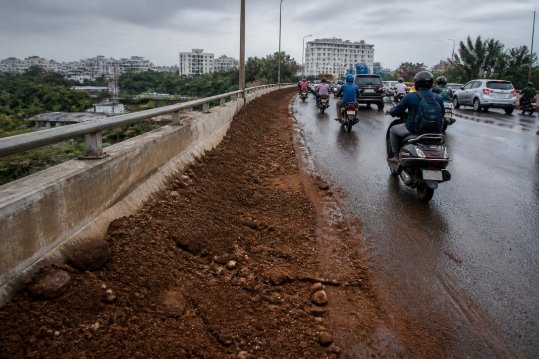 Loose soil spread across the Bengaluru ORR flyover carriageway, creating a hazard for two-wheeler riders