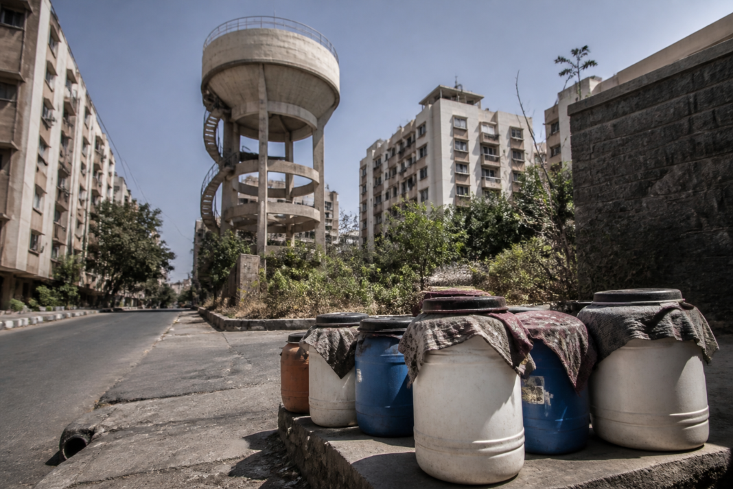 Pune water cut notice represented by a municipal water tank and residential buildings