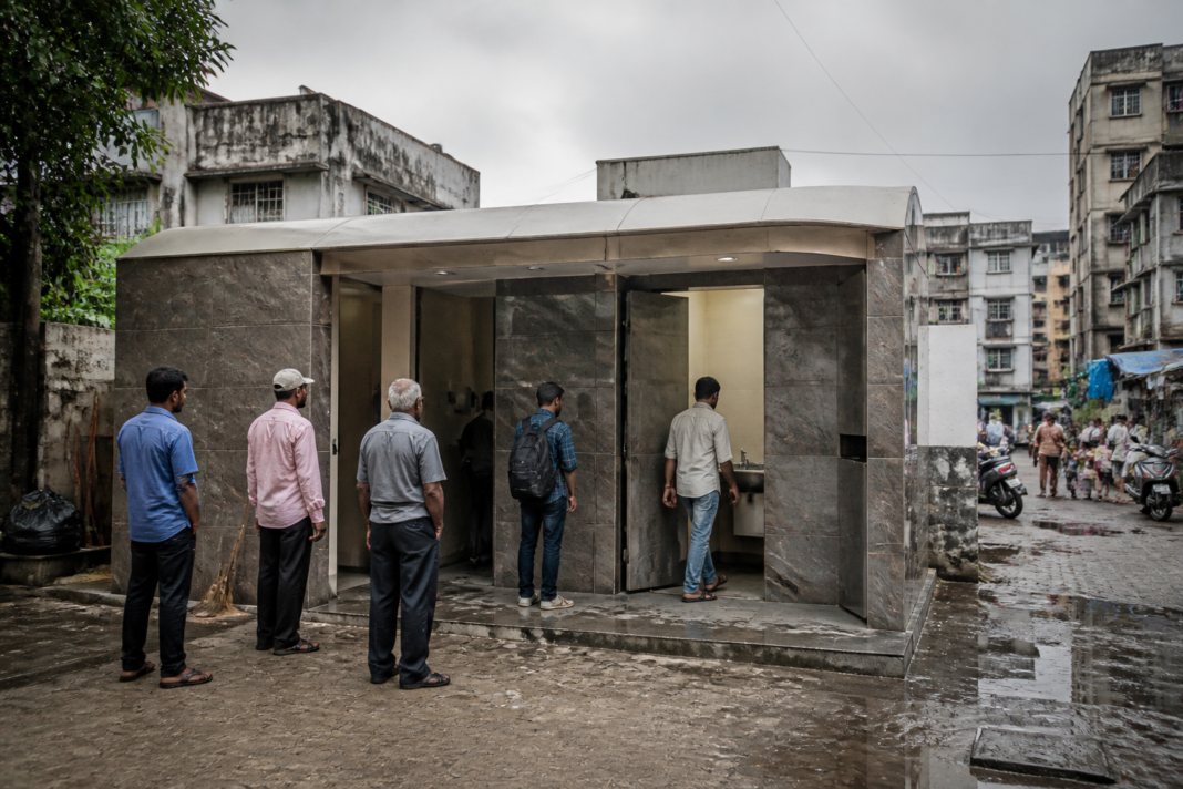 Mumbai public toilets in a dense urban neighbourhood with residents outside a civic sanitation complex