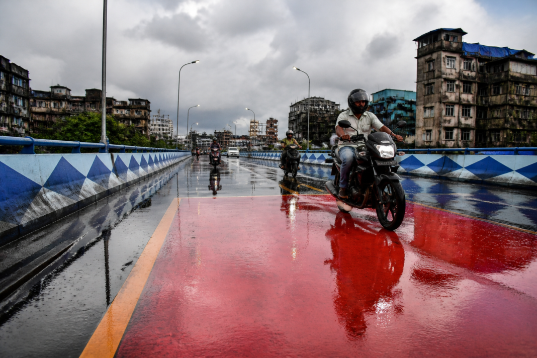 Motorbikes on a wet coloured surface of a Kolkata flyover after rain