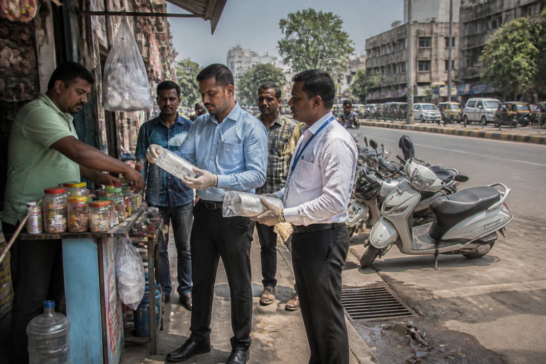 Ahmedabad plastic ban enforcement near a city pan stall and municipal road.