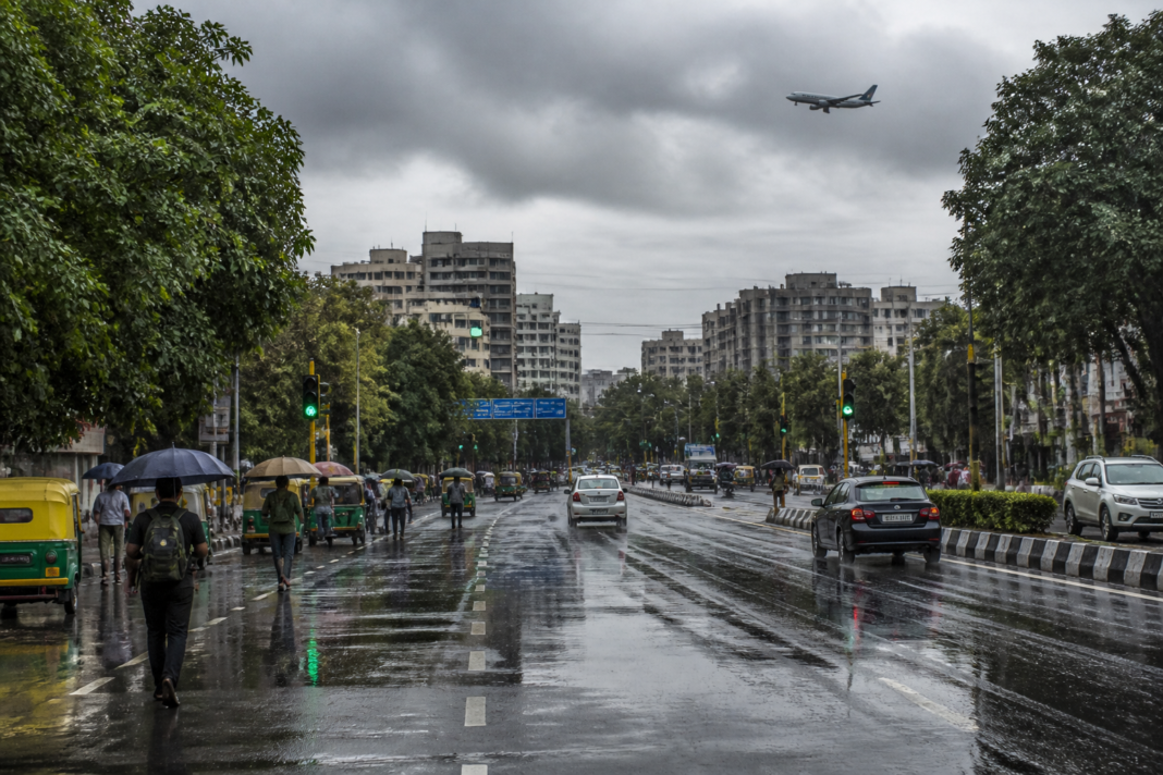 Delhi weather after rain, with cloudy skies over a wet urban road