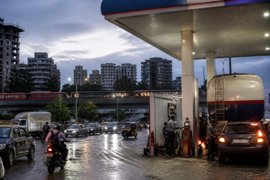 Indian OMC fuel losses shown through a busy urban petrol station and fuel transport tanker